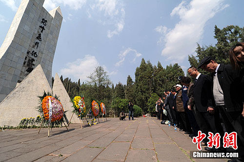 3月28日，几位飞虎队老兵与美国驻成都总领事一行齐聚昆明驼峰航线纪念碑下，共同缅怀飞虎队的英勇事迹，纪念驼峰航线通航70周年。图为老兵与美国驻成都总领事在纪念碑下默哀。中新社发 任东 摄 