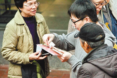 中银香港发售百元的纪念单钞，银行外有人以1，500元收购原价300元的两套单钞。图片来源：香港文汇报