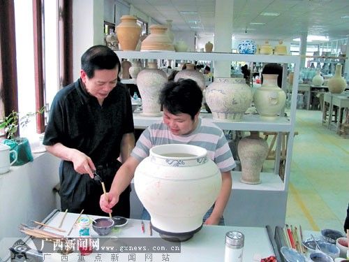 工人在纹饰轮廓中填涂好颜料，看起来与“真品”非常接近。